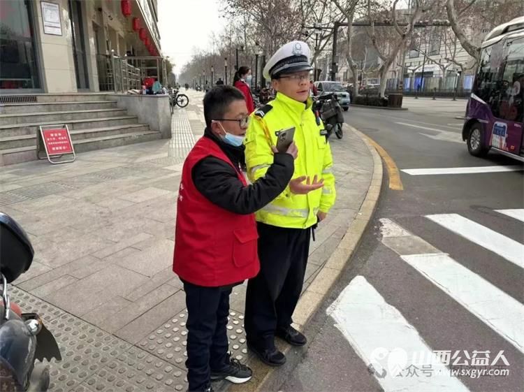 临汾市文明交通志愿者携手交警支队直属一大队交警在水厂十字岗联合开展了文明交通宣传一盔一带志愿服务活动 - 第3张