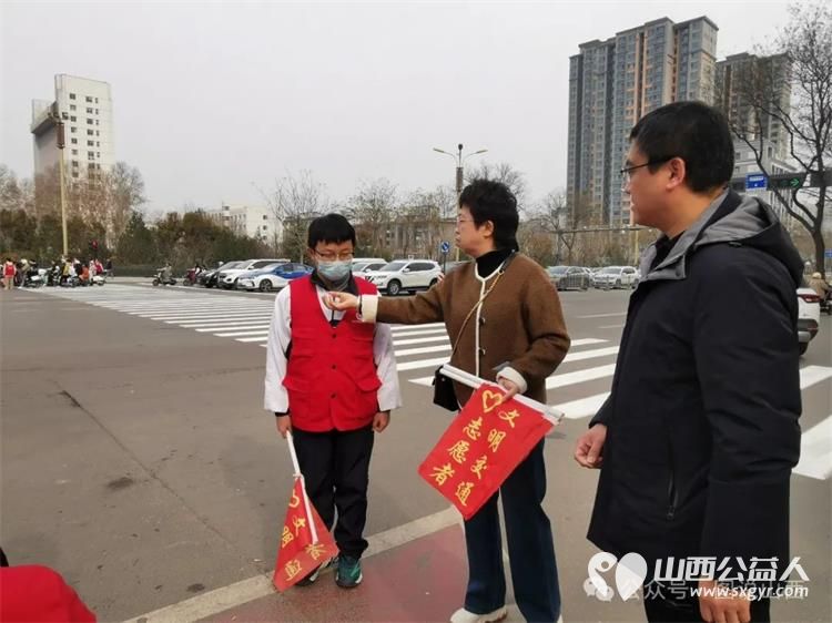 临汾市文明交通志愿者携手交警支队直属一大队交警在水厂十字岗联合开展了文明交通宣传一盔一带志愿服务活动 - 第8张