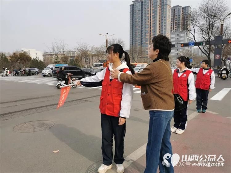 临汾市文明交通志愿者携手交警支队直属一大队交警在水厂十字岗联合开展了文明交通宣传一盔一带志愿服务活动 - 第6张