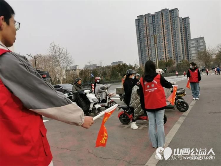 临汾市文明交通志愿者携手交警支队直属一大队交警在水厂十字岗联合开展了文明交通宣传一盔一带志愿服务活动 - 第7张