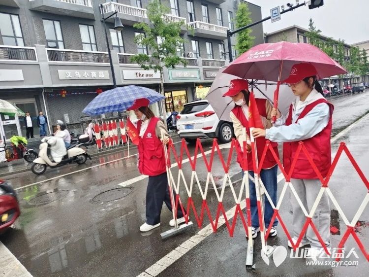 风雨坚守维护出行志愿暖心乐享尧都 假日临汾临汾市文明交通志愿者护交通保平安雨中街头闪烁着那片耀眼的志愿红 - 第2张