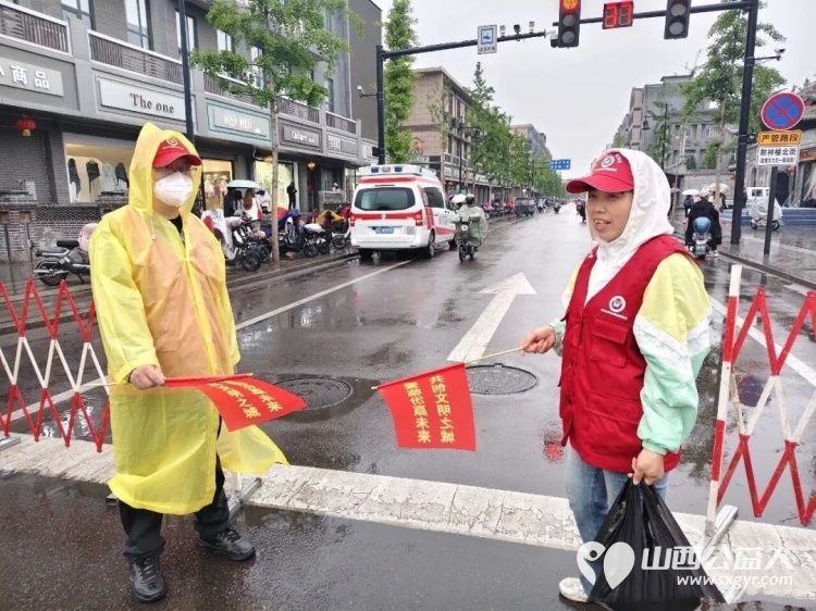 风雨坚守维护出行志愿暖心乐享尧都 假日临汾临汾市文明交通志愿者护交通保平安雨中街头闪烁着那片耀眼的志愿红 - 第3张