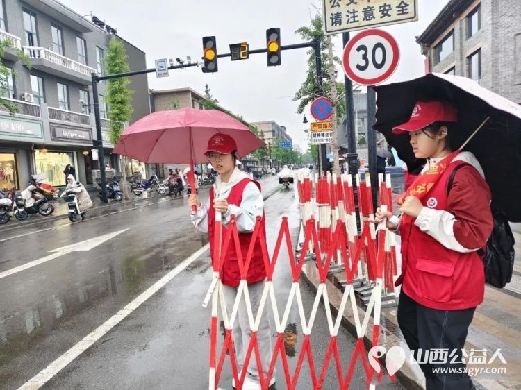 风雨坚守维护出行志愿暖心乐享尧都 假日临汾临汾市文明交通志愿者护交通保平安雨中街头闪烁着那片耀眼的志愿红 - 第5张
