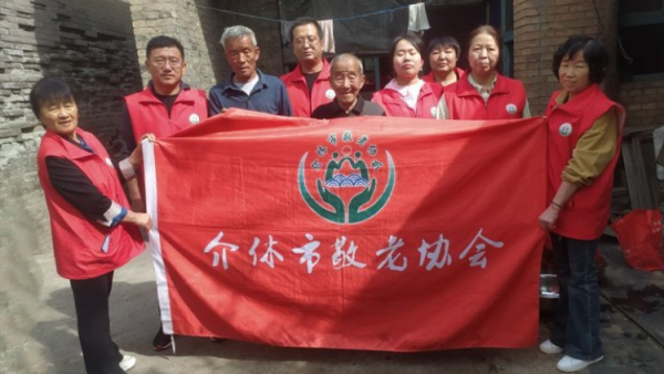 介休市敬老协会志愿者去张兰镇田堡村入户87岁特困老人米积盈家中为老人理发打扫室内外卫生