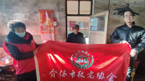 介休市敬老协会志愿者在绵山镇马堡村入户特困老人84岁马虎成家中为老人擦玻璃打扫卫生并为老人包爱心饺子