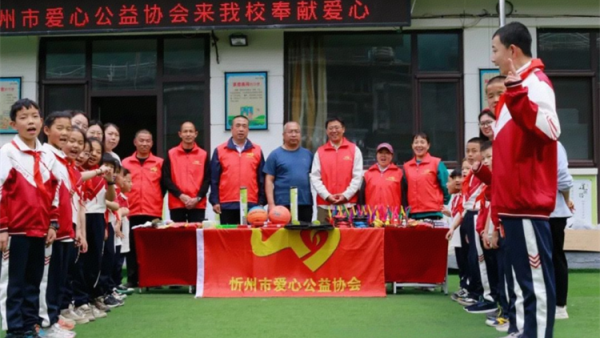 情暖校园爱心助学----忻州市爱心公益协会去五台县杨柏峪小学助学活动捐赠物资有羽毛球拍跳棋中性笔等学习用具和体育用品以及袜子大枣等生活用品