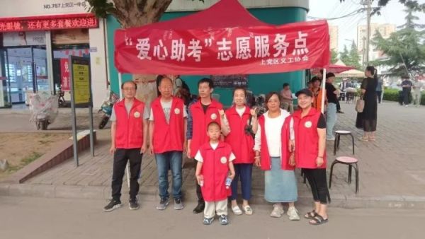 长治市上党区义工协会爱心助力高考志愿服务点协助交警维护考场周边交通秩序为考生及家长提供免费矿泉水