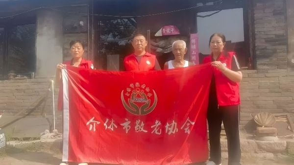 介休市敬老协会志愿者入户南两水村90岁特困任金明老人家为老人打扫室内外卫生做饭包饺子