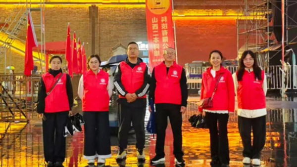 志愿服务----忻州市忻府志愿者风雨中一样有彩虹他们淋着雨撑着伞坚守在雨中随时准备为游客服务从未却步坚守如一