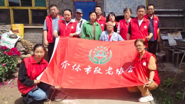 介休市敬老协会走进洪山镇下曹麻村入户85岁李根录老人家中为老人打扫室内外卫生刷洗锅碗瓢盆理发做饭包饺子